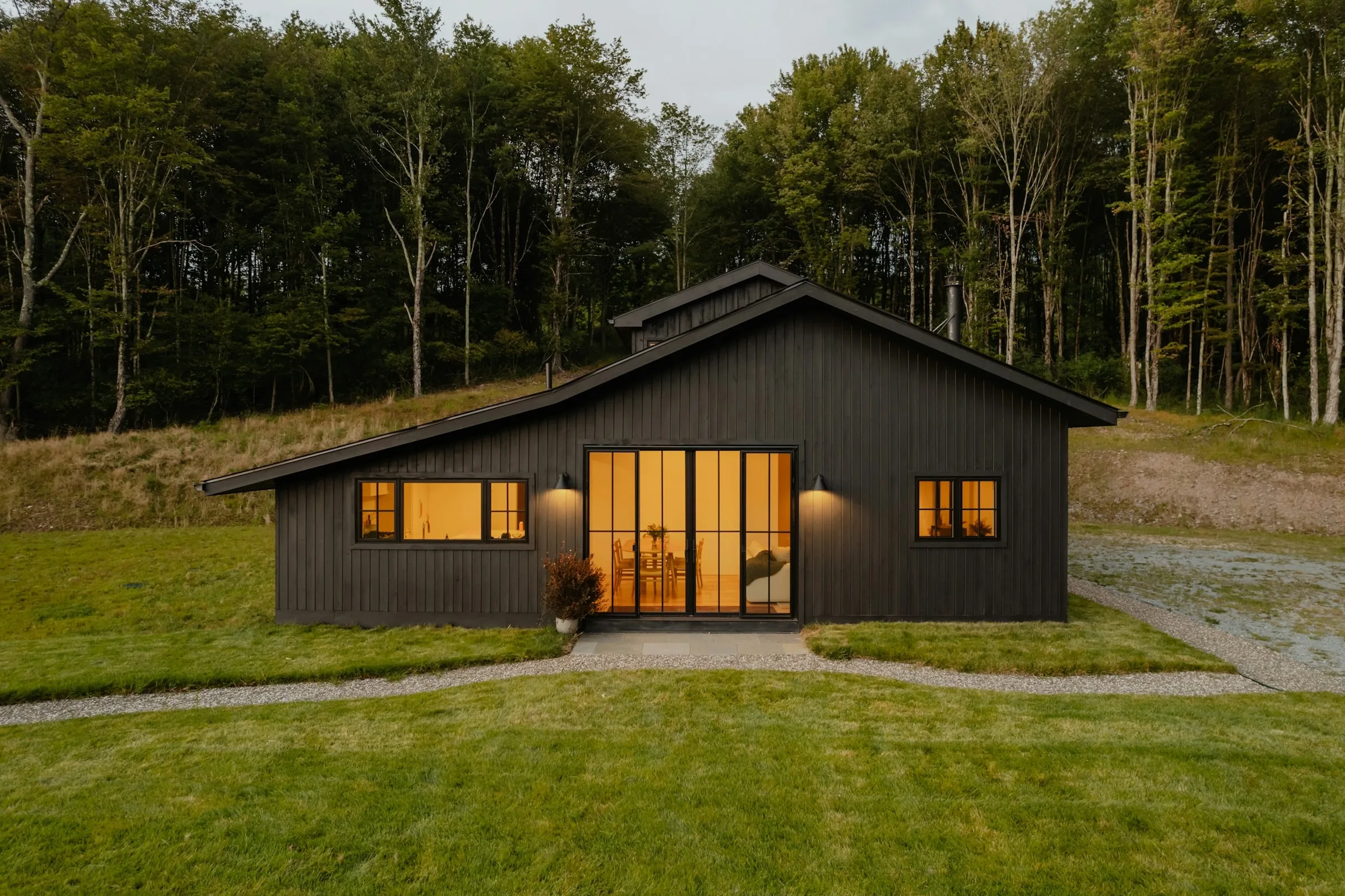 House finished in dark vertical board siding with timber accents