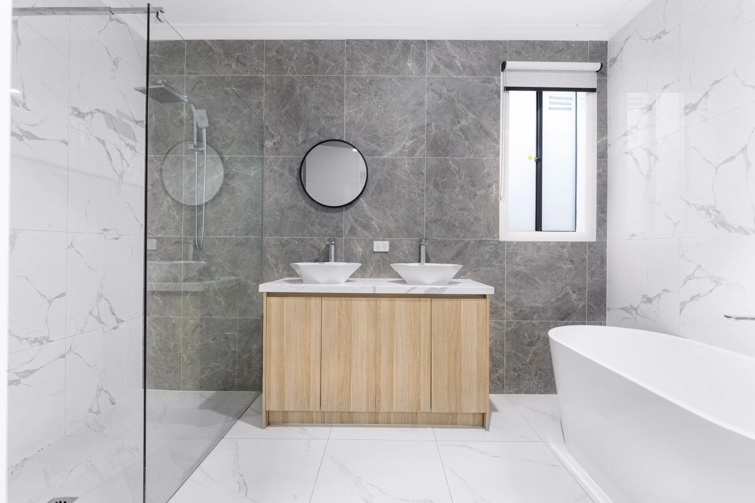 Remodeled bathroom with a glass walk-in shower, soaking tub and double vanity