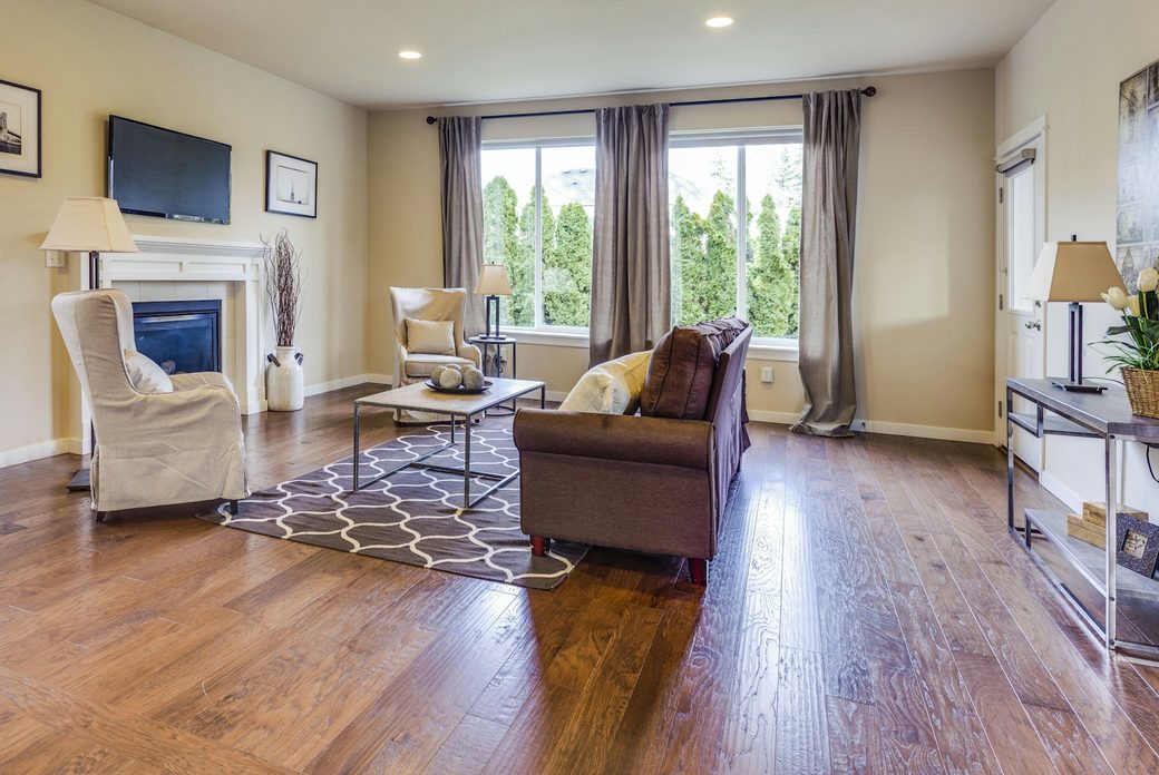 Living room with wide-plank hardwood floors, a fireplace and a large window