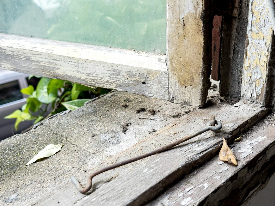 Closeup of a weathered windowsill with peeling paint