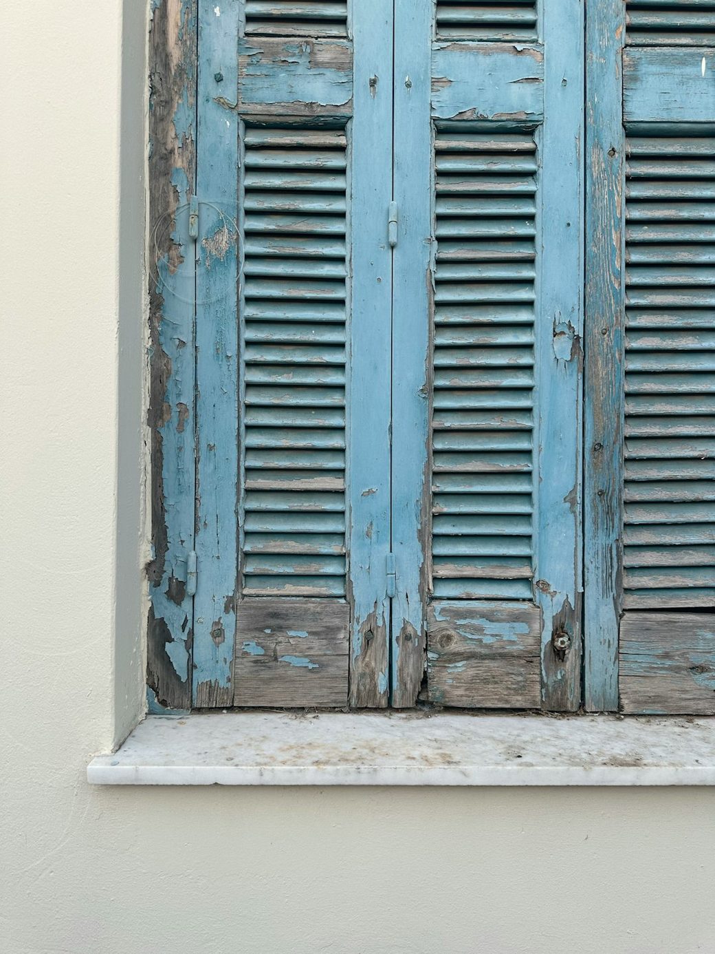 Closeup of weathered shutters with peeling paint