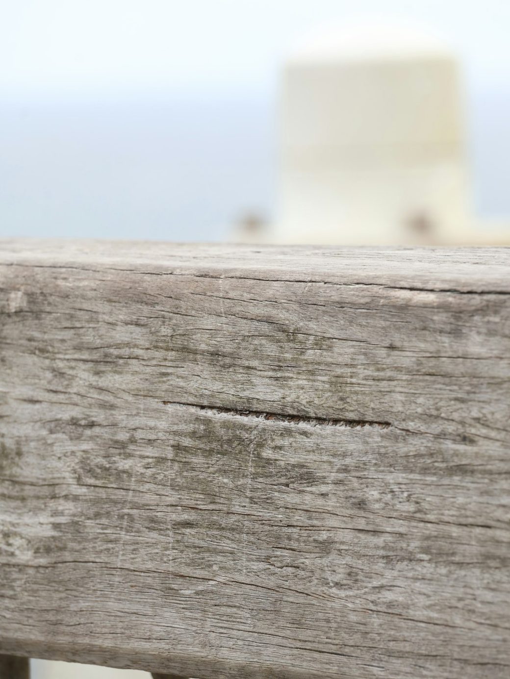 Closeup of weathered wood railing with a split