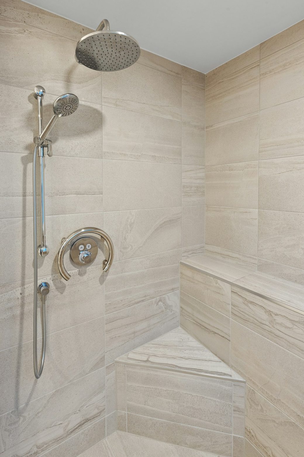 Corner shower with tan tile and gold fixture