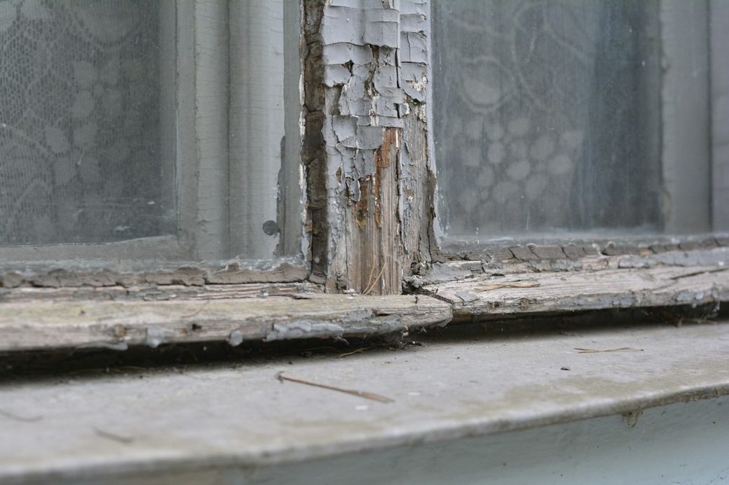 Weathered wood window sill with rot damage