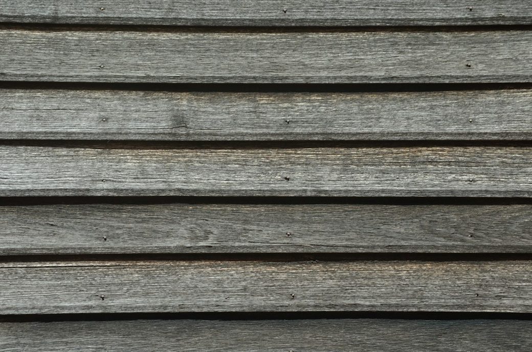 Weathered wood siding closeup with knot