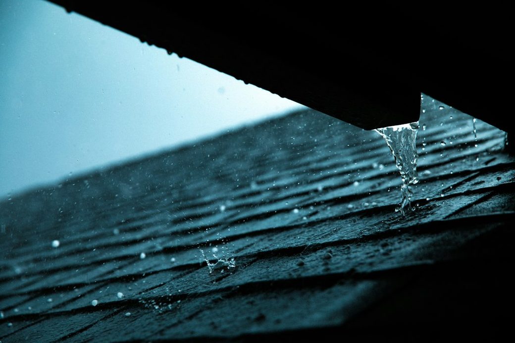 Rain running off a roof shingle edge
