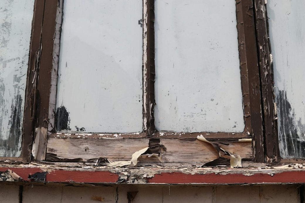 Peeling paint and weathered wood on a window frame