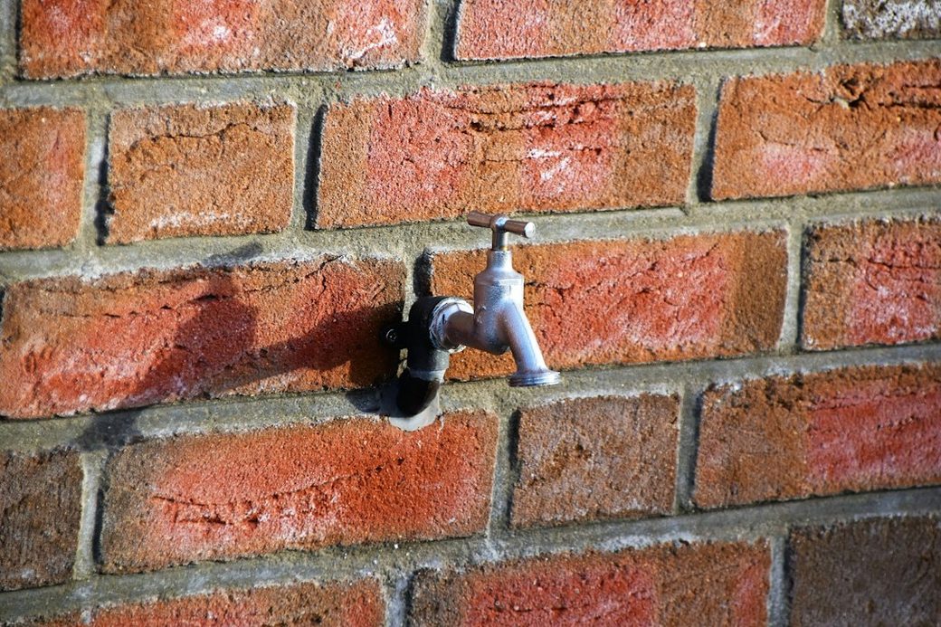 Outdoor faucet mounted on a house wall