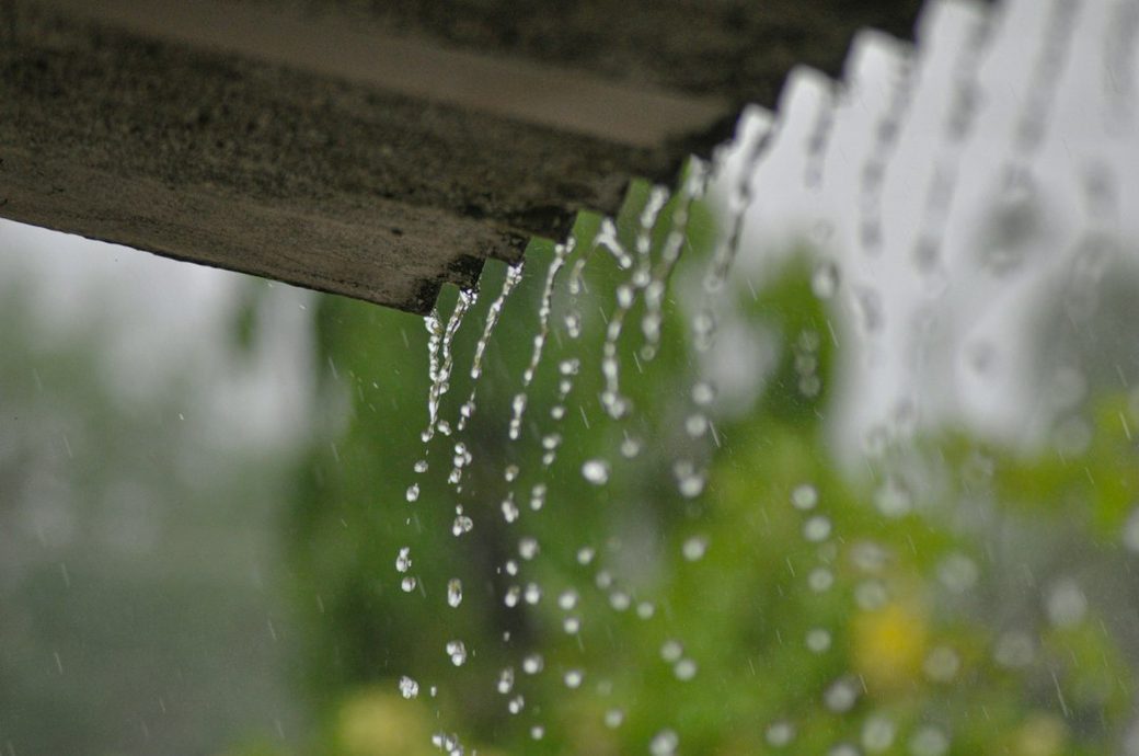 Rain water dripping from a roof gutter
