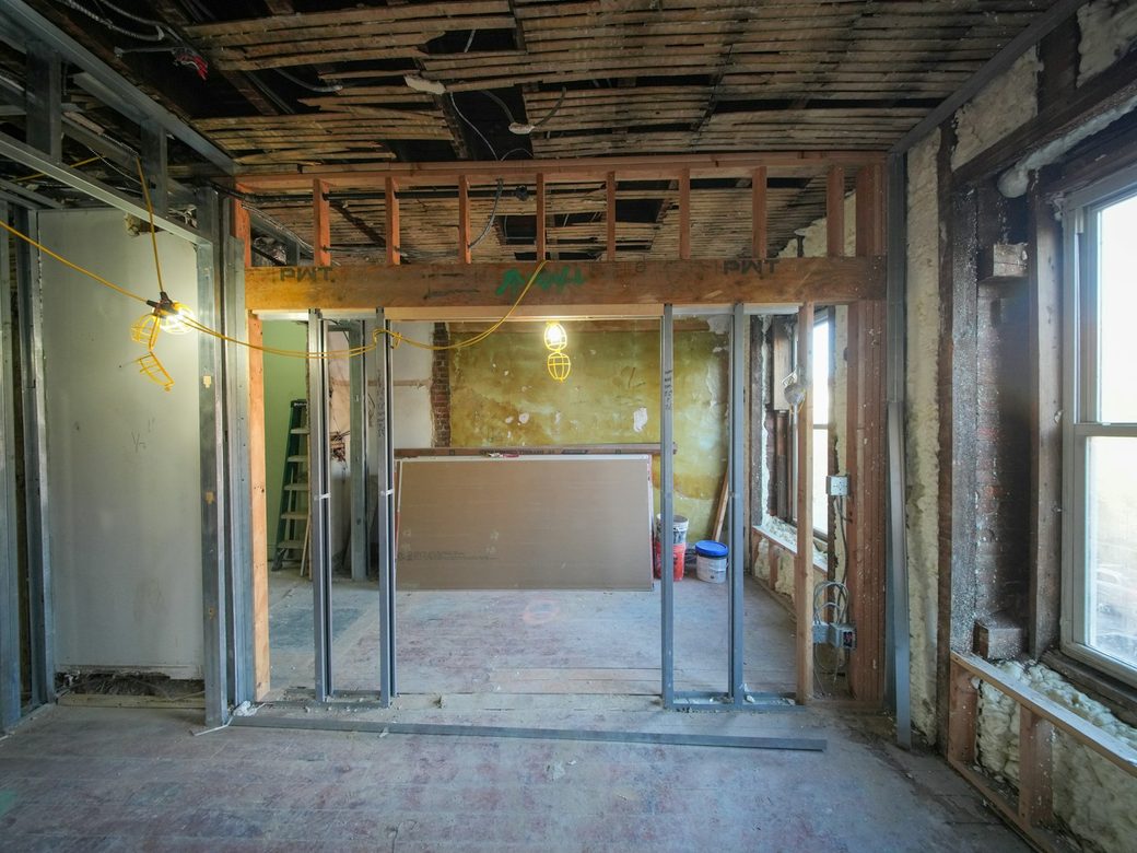 Wood header beam spanning a widened wall opening during an interior remodel